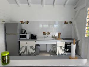 a kitchen with a sink and two chairs in it at Tropical Lodge in Petit-Bourg
