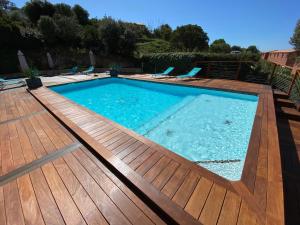 a large swimming pool with a wooden deck at Casa Léna in Propriano