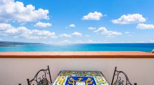 a balcony with a table and a view of the ocean at Apartment Casa Beatrice in Pizzo