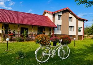 a white bike parked in front of a house at Serenity Garden Villa in Runcu