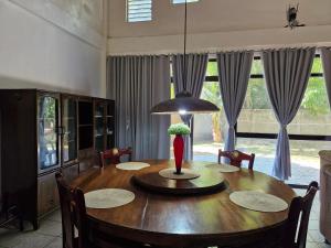 a dining room table with a vase of flowers on it at Casa Maria in Sibulan