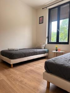 a bedroom with two beds and a window at Escale Confort A1-2 Chambres Stationnement Facile in Roye