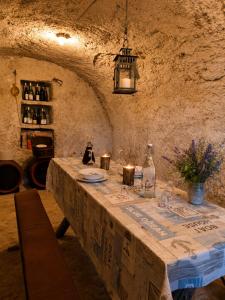 a table in a stone room with a bottle of wine at 100 éves Présház in Badacsonyörs