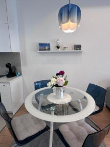un tavolo di vetro con un vaso di fiori sopra di Apartman Mango & Mia a Trebinje Altre 27 foto