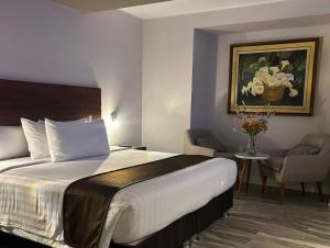a hotel room with a bed and a vase of flowers at Hotel Inclan in Lima