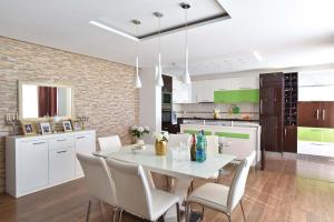 a kitchen and dining room with a white table and chairs at Vila sa bazenom Emar, Budva in Krimovice