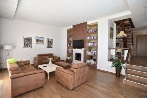 a living room with two couches and a tv at Vila sa bazenom Emar, Budva in Krimovice