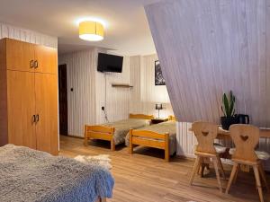 a bedroom with a bed and a table and chairs at U Hajduka in Murzasichle