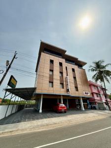 a building with a car parked in front of it at Aero Inn in Nedumbassery