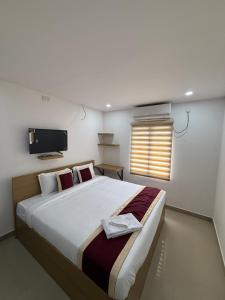 a bedroom with a large bed with a tv on the wall at Aero Inn in Nedumbassery