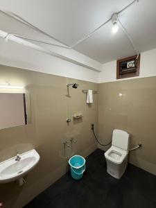 a bathroom with a white toilet and a sink at Aero Inn in Nedumbassery +28 photos