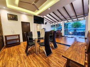 a dining room with a glass table and black chairs at Breezy River in Kalutara