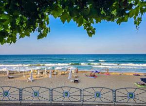 a beach with chairs and umbrellas and the ocean at Luxe 1 apartments in Obzor