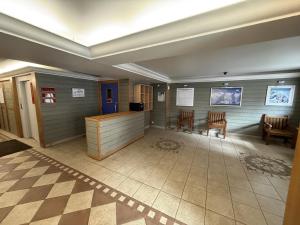 a lobby with chairs and a counter in a building at Les balcons de Valmi vue montagne Piscine in Valmeinier