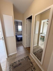a hallway with a large mirror in a room at Les balcons de Valmi vue montagne Piscine in Valmeinier