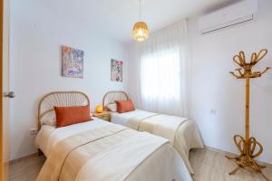 a bedroom with two beds and a window at Apto Oasis Playa & Golf Almerimar in Almerimar +17 photos
