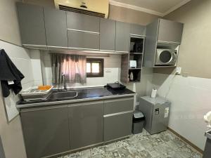 a small kitchen with a sink and a microwave at Portal La Delfina in Ciudad Lujan de Cuyo