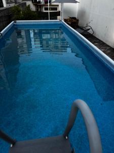 a swimming pool with blue water in a building at SUITE Meghan home in Catania