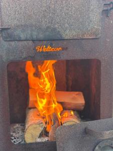a fire inside of a pizza oven with flames at Sinne - Ecohuisjes Terschelling in Midsland
