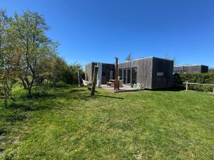 a small house in a field with a grass yard at Sinne - Ecohuisjes Terschelling in Midsland
