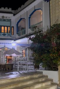 a patio with tables and umbrellas in front of a building at Dar morjana in Chott Meriem