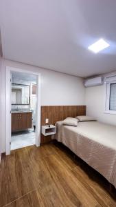 a bedroom with two beds and a wooden floor at Restaurante e Pousada Andrade in Centenário