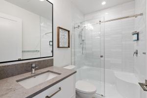 a bathroom with a shower and a sink and a toilet at Saratoga Beach Villa 6 in Oyster Bay +19 photos