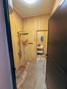 a hallway with a shower in a room with wooden walls at CATU Colors and Comfort, A Choice of Studios in Dakar in Dakar