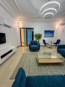 a living room with blue couches and a tv at CATU Colors and Comfort, A Choice of Studios in Dakar in Dakar