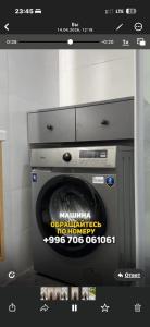 a washing machine with a sign on the front of it at BonHome квартиры in Bulan Sogottuu