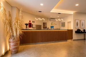 a lobby with a bar and a plant at Smart Hotel GRU in Guarulhos