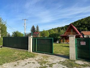 two green gates in a yard with a house at Vikendica Bosnjak in Sarajevo