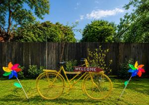 a yellow bike parked in a yard with a welcome sign at Serenity Garden Villa in Runcu