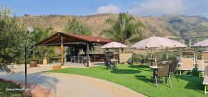 a patio with tables and chairs and umbrellas at B&b Le paradis in Castel di Tusa