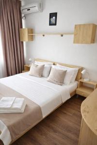 a bedroom with a large bed with white sheets and pillows at Adori Boutique in Eforie Nord
