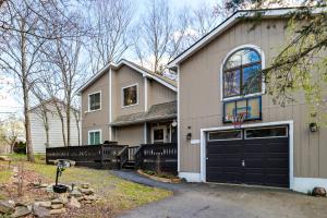 a house with a black garage door and a basketball hoop at Lake Access & Game Room! Poconos Resort Getaway in Tobyhanna