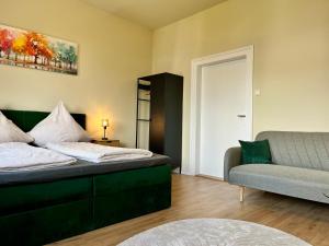 a bedroom with a bed and a couch at Apartments am Burgberg in Bad Harzburg