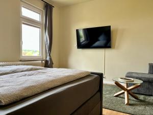 a bedroom with a bed and a television on the wall at Apartments am Burgberg in Bad Harzburg