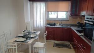 a kitchen with wooden cabinets and a table with chairs at P&M House in Agrinio