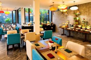 a dining room with tables and chairs and a restaurant at Happy Life Memories Hoi An Hotel & Spa in Hoi An