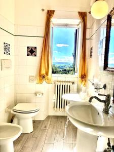 a bathroom with a toilet and two sinks and a window at Boutique Hotel L'Imperatrice -Vicinissimi a Valdichiana Designer Village- in Foiano della Chiana +24 photos
