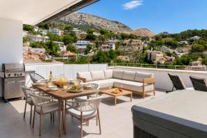 a patio with a couch and a table and chairs at Altea Sol Marina Apartment by NRAS in Altea