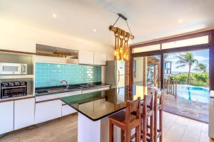 a kitchen with a island with a view of a pool at Ocean View Beira-Mar no Centro de Canoa in Canoa Quebrada