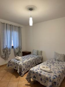 a bedroom with two beds and a window at Casa Speranza in Narzole