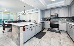 a kitchen with white cabinets and a large island at Phoenix Gulf Towers 805 condo in Gulf Shores