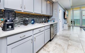 a large kitchen with white cabinets and a tile floor at Phoenix Gulf Towers 805 condo in Gulf Shores