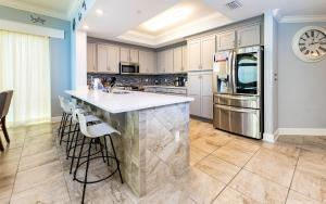 a kitchen with a large island with white counter tops at Phoenix Gulf Towers 805 condo in Gulf Shores