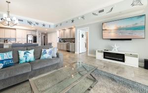 a living room with a couch and a tv at Phoenix Gulf Towers 805 condo in Gulf Shores +74 photos