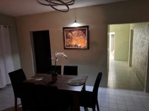 a dining room table with chairs and a painting on the wall at Casa Flores in Río Blanco