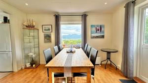 a dining room with a wooden table and chairs at Lofotenfeeling, Haverringen Panorama in Vestvågøya